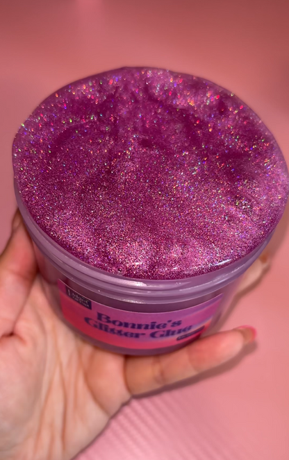 Purple Holographic Glitter slime in container labeled “Bonnie’s Glitter Glue” with pink background 