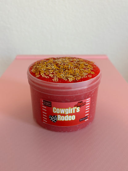 Red snow fizz slime in container marked “Cowgirl’s Rodeo” with gold star glitter in front of pink background 
