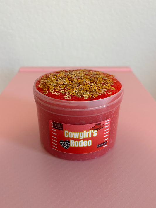 Red snow fizz slime in container marked “Cowgirl’s Rodeo” with gold star glitter in front of pink background 