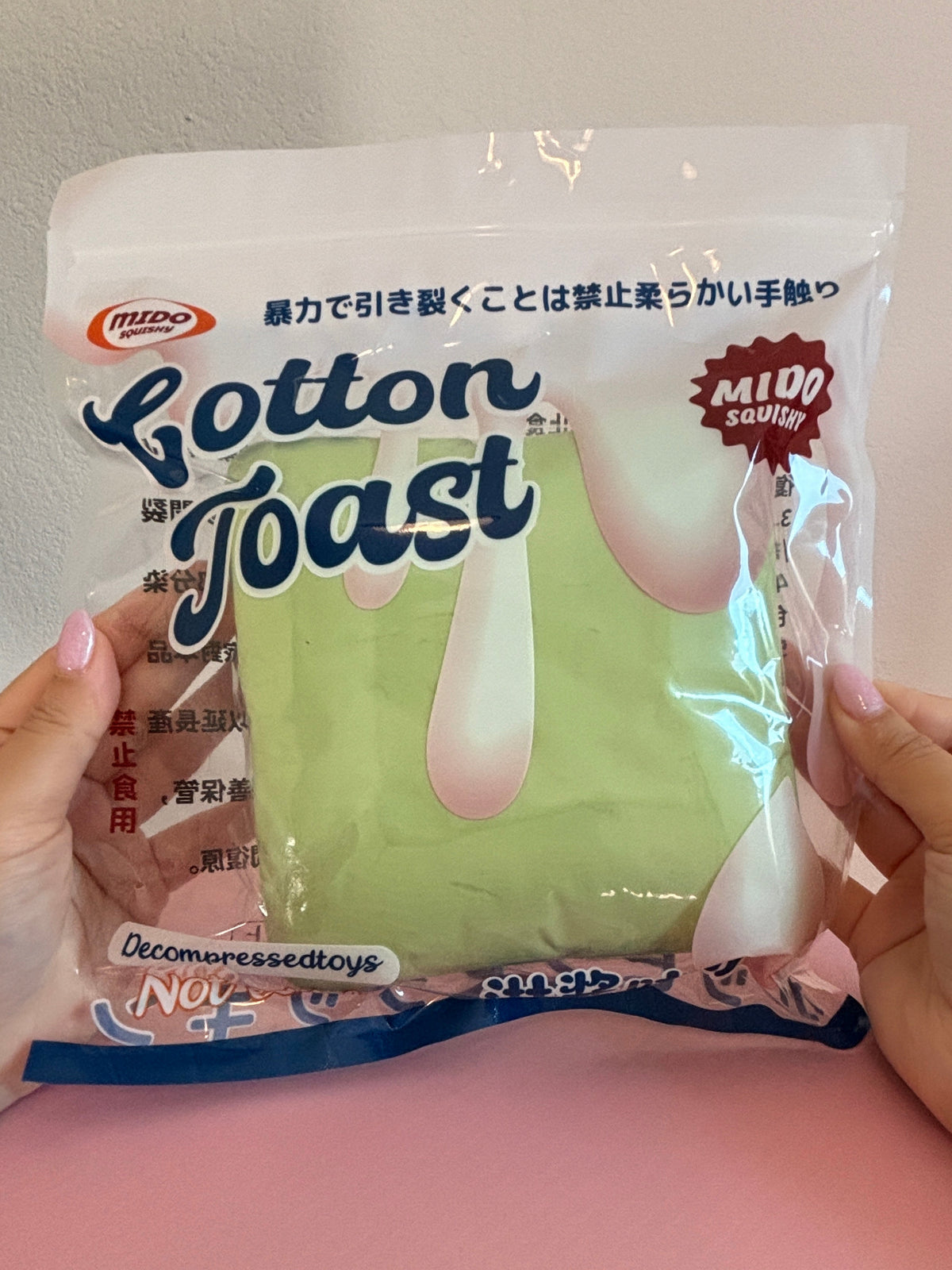 Green Jumbo Toast Squishy in a plastic bag with the branding ‘Mido’ and the words ‘Cotton Toast’ on the bag.